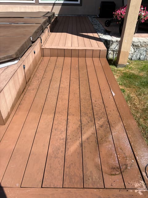 Composite deck stained with dirt and grime before pressure washing